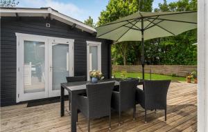 a table and chairs with an umbrella on a deck at Gorgeous Home In Samsø With Kitchen in Onsbjerg