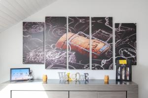 a dining room with four paintings on the wall at « Le Bidule », logement au cœur de la Champagne in Chouilly