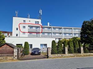 a white building with a red circle on the side of it at Wicher Hel - mieszkanie blisko centrum in Hel