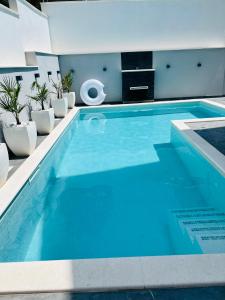 een groot zwembad met blauw water in een huis bij Apartments Imperium in Trogir