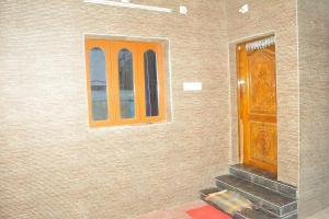 - un bâtiment avec une porte en bois et une fenêtre dans l'établissement Feels Like Home, à Tiruchchendūr