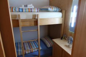 2 Etagenbetten in einem kleinen Zimmer mit einem Schreibtisch in der Unterkunft Apartment Heidi in Bad Goisern
