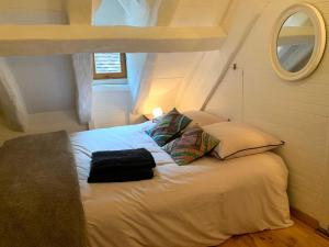 a small bedroom with a bed with two pillows at La Lotoise gîte au Coeur De Saint-Cirq-Lapopie in Saint-Cirq-Lapopie