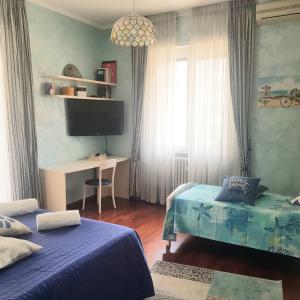 1 dormitorio con 2 camas, escritorio y TV en Marco's Apartment Colosseum, en Roma