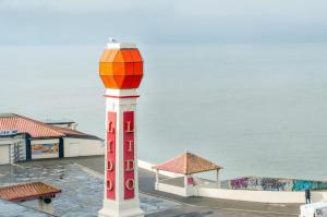 a red and white tower with an orange top next to the water at Seaview Oasis - Margate Abode - Sleeps 4 in Kent