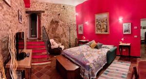 a bedroom with pink walls and a bed and stairs at L'Allogio - Town House Suite in Campobasso