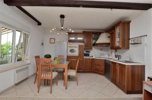 a kitchen with wooden cabinets and a table and chairs at Apartment RELAX Opatija in Opatija