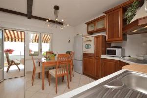 a kitchen with a table and a dining room at Apartment RELAX Opatija in Opatija