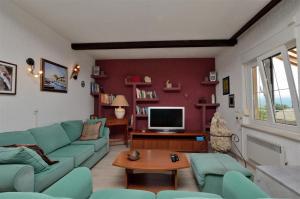 a living room with a blue couch and a tv at Apartment RELAX Opatija in Opatija