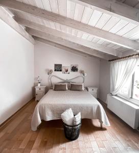 a white bedroom with a bed and a window at Kaloudis Studios & Apartments in Dassia