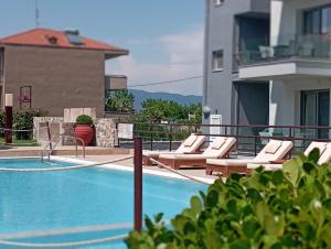 a swimming pool with lounge chairs on a building at Plakoudis Rooms in Stavros