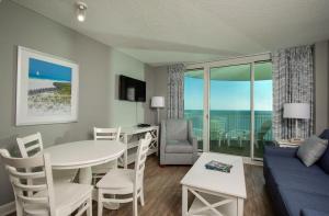 a living room with a table and a couch and a dining room at Avista Resort in Myrtle Beach