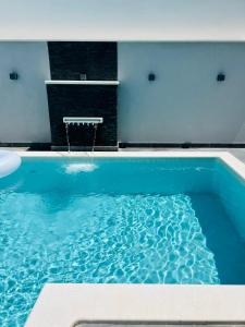 een blauw zwembad met een tafel op de achtergrond bij Apartments Imperium in Trogir