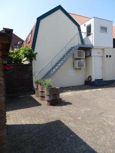 une maison blanche avec un escalier sur son côté dans l'établissement Guesthouse Wormer, à Wormer