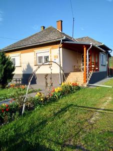 a house with flowers in front of it at Kökörcsin Vendégház in Tornaszentandrás