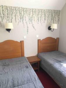 1 Schlafzimmer mit 2 Betten und 2 Lampen an der Wand in der Unterkunft Évasion de Rêve nature ,lac & Équitation in Monflanquin
