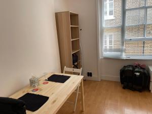 a small room with a wooden table and a window at Sootheus - Soho7 in London