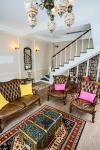 a living room with leather furniture and a staircase at Quinta das Candeias in Candelária