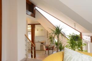 a living room with a yellow couch and a kitchen at Les Glycines du Sommerberg in Niedermorschwihr