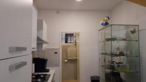a kitchen with a glass shelf next to a door at APARTMAN ROSEMARY in Rijeka +12 photos