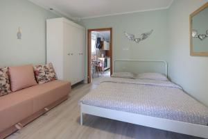 a bedroom with a bed and a couch at Ada in Rijeka