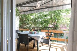 a table and chairs on a patio with a balcony at Ada in Rijeka