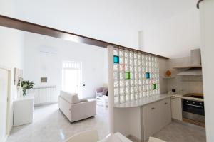 Il comprend une cuisine aux murs blancs et une grande fenêtre. dans l'établissement Dimora Azzurra, à Pezze di Greco
