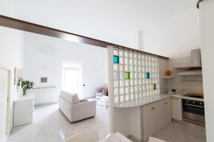 a kitchen with white walls and a large window at Dimora Azzurra in Pezze di Greco