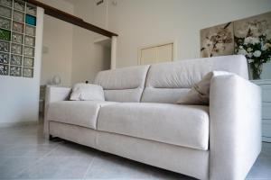 - un canapé blanc dans le salon dans l'établissement Dimora Azzurra, à Pezze di Greco