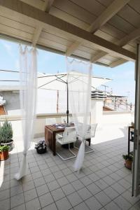 een patio met witte gordijnen en een tafel en stoelen bij Casa Vivì in Porto SantʼElpidio