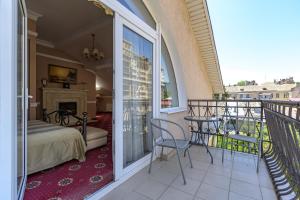 a room with a balcony with a bed and a bed and a fireplace at Gostiniy Dvor in Odesa