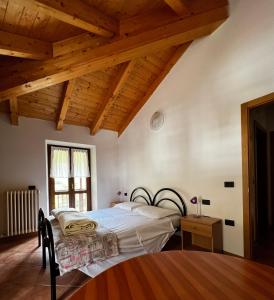 a bedroom with a bed and a wooden ceiling at Appartamenti Casa Miravalle in Enguiso