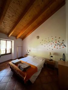 a bedroom with a large bed and a wooden ceiling at Appartamenti Casa Miravalle in Enguiso