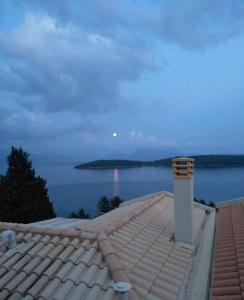 a tile roof with a view of the water at Sunrise guest house in Nydri