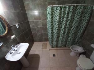 a bathroom with a sink and a toilet and a shower at Quinta La Martita in Ingeniero Giagnoni
