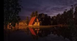 a house sitting on top of a lake at night at Quinta La Martita in Ingeniero Giagnoni