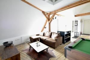un soggiorno con divano e tavolo da biliardo di frigg flats I Industrial Style I Loft I Billard I a Landshut