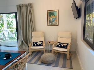 a living room with two chairs and a table at Naturalis - Oceanview Residences in Mahe
