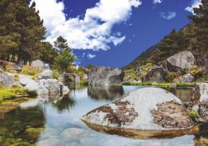 a river with a large rock in the water at Casas dos Senadores by Vale do Zêzere Hotel in Manteigas