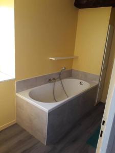een badkamer met een ligbad en een gele muur bij Gite TY KERMORZU 