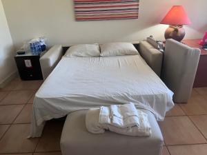 1 dormitorio con cama blanca y sofá en Aurora Luxury Suite con acceso a la playa, en Chame