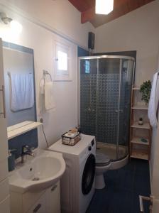 uma casa de banho com um chuveiro, um WC e um lavatório. em Mayia Sunset sea front house Gouves Heraklion em Gouves