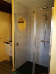 een douche met een glazen deur in de badkamer bij Gite TY KERMORZU 