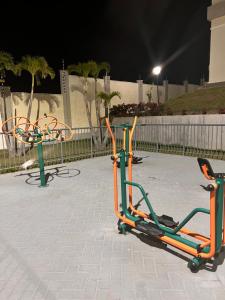 a group of exercise equipment on a sidewalk at night at Apto ao lado do Shopping Caruaru próximo ao pátio unidade 302 in Caruaru