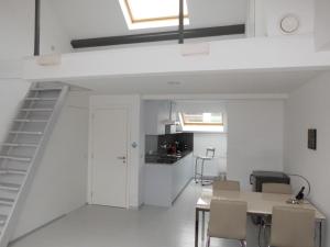 a kitchen and dining room with a staircase in a loft at Aparthotel Midi Residence in Brussels