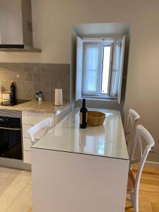 una cucina con piano di lavoro bianco e finestra di Discover Lisbons History - Stylish apartment in Alfama a Lisbona