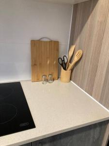 a kitchen counter with two glasses and a knife block at Urban Awe Apartment: Sarona City in Gaborone