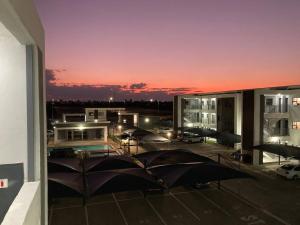 two umbrellas sitting on the balcony of a building at Urban Awe Apartment: Sarona City in Gaborone