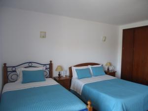 two beds sitting next to each other in a bedroom at Casa Mar Azul in Vila Nova de Milfontes