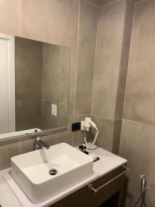 a bathroom with a white sink and a mirror at Black Diamond Hotel Dhermi in Dhërmi